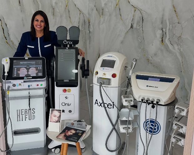 Equipamentos da Belíssima Laser Estética Avançada lado a lado em sala com parede de mármore: Hérus HIFU, Ônix, Axcel e uma plataforma Medical San, com uma profissional de uniforme ao lado